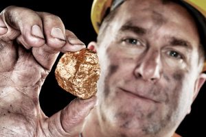 a miner shows off a gold nugget